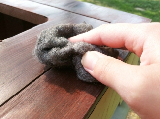 person using steel wool when finishing a cabinet