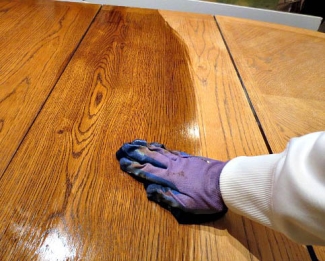 person wearing gloves while finishing a table